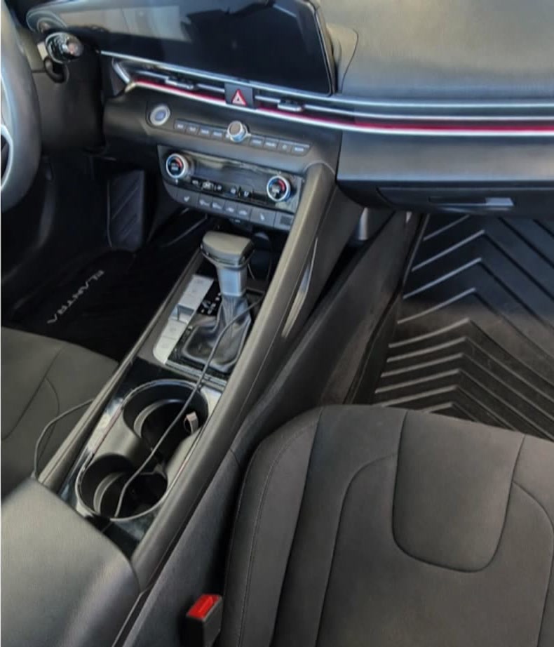 The same center console after an interior deep clean — cup holders, trim and seats cleaned