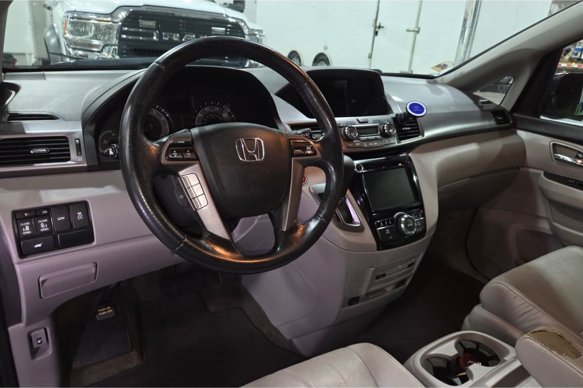 The same Honda Odyssey interior after a full detail — upholstery, carpet and console cleaned