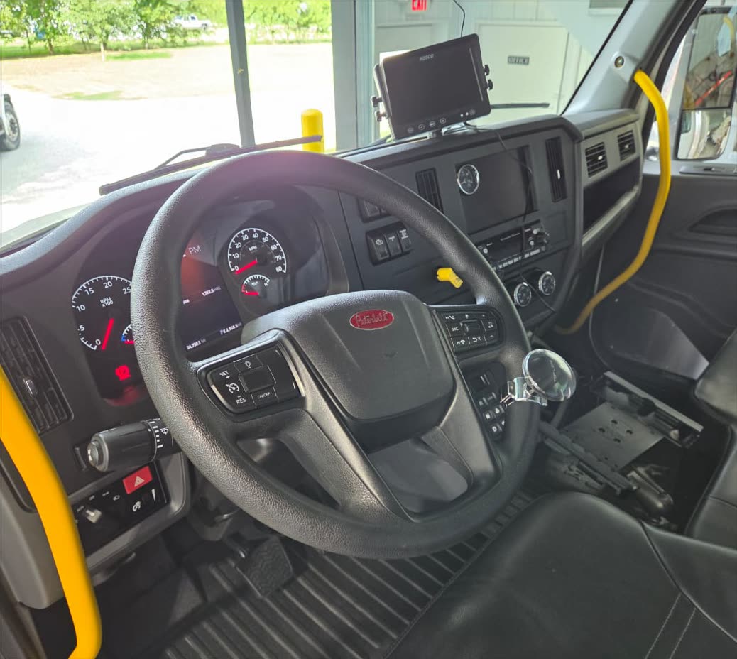 The cleaned cab of a Peterbilt commercial truck — detailed dashboard, steering wheel and floor mats