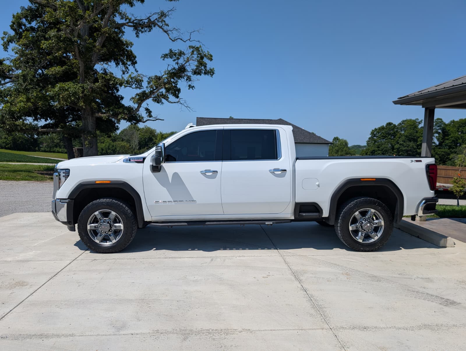 A white GMC Sierra 2500 photographed side-on in daylight after a full detail