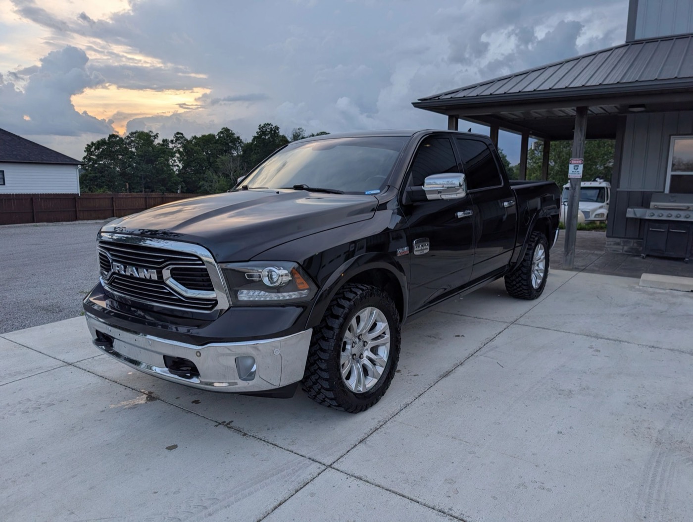 A dark RAM 1500 reflecting an evening sky after detailing